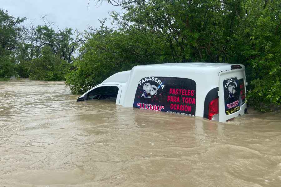 Camioneta de panadería queda casi cubierta por el agua en camino de terracería en Llera, Tamaulipas