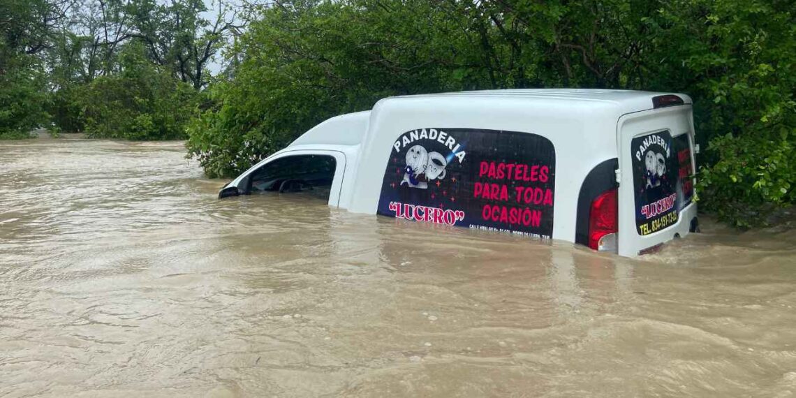Camioneta de panadería queda casi cubierta por el agua en camino de terracería en Llera, Tamaulipas