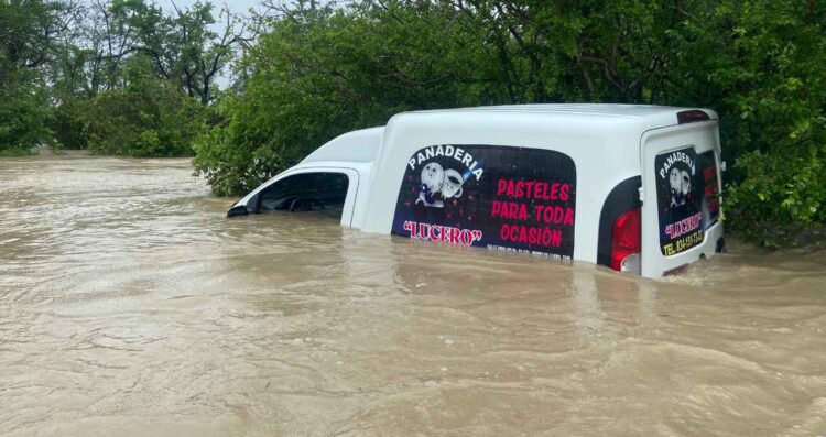 Camioneta de panadería queda casi cubierta por el agua en camino de terracería en Llera, Tamaulipas
