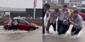 Trabajadores ayudan a mujer que quedó varada en avenida de Monterrey tras las lluvias